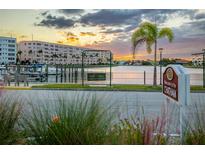 Beautiful waterfront community view with palm trees and dock at sunset, showcasing a peaceful location at 3018 59Th S St # 209, Gulfport, FL 33707