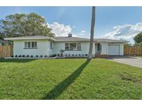 Charming single story home with a well maintained front yard, driveway, and attached garage at 3118 Adrian Ave, Largo, FL 33774