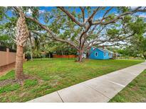 Charming blue cottage with a lush lawn and mature trees in a desirable neighborhood at 320 Broadway, Dunedin, FL 34698