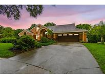 Charming home with well-manicured landscaping, a spacious driveway, and a two-car garage at 3308 Landing Pl, Palm Harbor, FL 34684