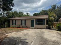 Cozy single-story home featuring neutral siding, green shutters, well-maintained landscaping, and a spacious driveway at 4793 Pleasant Ave, Palm Harbor, FL 34683