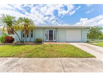 Charming single-story home featuring a well-maintained lawn, palm trees, and a clean, attached garage at 5377 Springwood Blvd, Pinellas Park, FL 33782