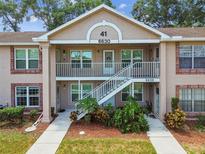 Charming two-story condo featuring a well-maintained lawn and exterior stairs at 6630 Spring Flower Dr # 14, New Port Richey, FL 34653