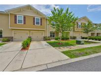Charming townhome featuring a one car garage, well-maintained lawn, and mature landscaping at 9508 Tocobaga Pl, Riverview, FL 33578
