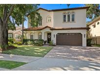 Beautiful two-story home featuring a manicured lawn, tile roof, a paved driveway, and an attached two-car garage at 3118 W Bay Villa Ave, Tampa, FL 33611