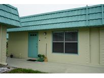 Charming condo with turquoise accents, including door and trim, creating a vibrant and welcoming entrance at 101 Cambridge Trl # 205, Sun City Center, FL 33573