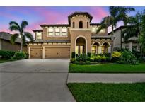 Stunning two-story home featuring a three-car garage and lush landscaping in a tropical setting at 11407 Drifting Leaf Dr, Riverview, FL 33579