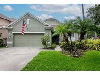 Charming single-story home with a lush green lawn, mature landscaping, and an attached two-car garage at 11623 Greensleeve Ave, Tampa, FL 33626