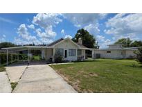 Charming single-story home featuring a front yard, covered parking, and lovely curb appeal at 13330 Fort King Rd, Dade City, FL 33525