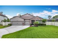 Beautiful single-story home featuring a well-manicured lawn and a two-car garage with decorative stone accents at 18079 Romanesque Ct, Spring Hill, FL 34610