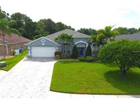 Charming single-story home with a paver driveway, lush lawn, and manicured landscaping at 1842 Ridgelake Ct, Wesley Chapel, FL 33543