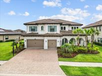 Stunning two-story home featuring a tile roof, paver driveway and meticulously landscaped front yard at 28565 Picana Ln, Wesley Chapel, FL 33543