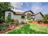Attractive home exterior featuring lush landscaping, a well-manicured lawn, and a neutral color scheme at 3089 Ashland Ter, Clearwater, FL 33761