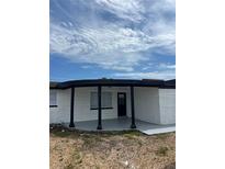 Inviting covered front entrance with fresh paint and black accents adds curb appeal to this charming home at 3844 Cedarwood Dr, Holiday, FL 34691