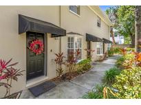 Charming condo front door with a black awning, floral wreath, and a 'Welcome' mat for a warm invitation at 409 S Audubon Ave # 3, Tampa, FL 33609