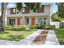 Charming townhome featuring an eye-catching orange front door and a well-manicured lawn and walkway at 4206 W North B St # 1, Tampa, FL 33609