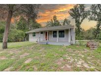Charming single-story home featuring a cozy front porch and well-maintained lawn, perfect for outdoor relaxation at 5290 Cyril Dr, Dade City, FL 33523