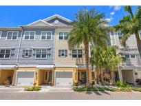 Charming townhomes boast a bright exterior, complemented by lush palm trees and beautiful landscaping at 6049 Moorings S Dr, St Petersburg, FL 33712