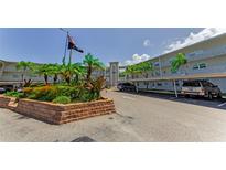 View of condo exterior with parking and landscaping, plus American flag at 952 Virginia St # 303, Dunedin, FL 34698