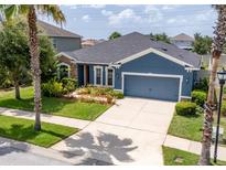 Charming blue single-story home with well-maintained landscaping and a spacious two-car garage at 11038 Spring Point Cir, Riverview, FL 33579