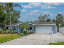 Charming single-story home featuring a two-car garage, manicured lawn, and beautiful landscaping at 111 Carlyle Dr, Palm Harbor, FL 34683
