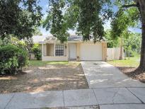 Charming single-story home with a well-manicured front yard, a covered front porch, and an attached garage at 12615 Logan Pl, Tampa, FL 33625