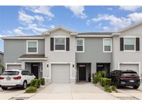 Charming townhome featuring a one car garage, neutral paint, and landscaped front yard at 16624 Maude Dr, Wimauma, FL 33598