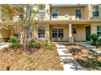 Inviting townhouse exterior featuring a covered porch and well-maintained landscaping at 213 Draw Bridge Ln, Valrico, FL 33594