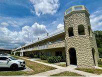 Multi-level building showcasing the architecture with stone tower and white balcony railings at 2391 Sumatran Way # 37, Clearwater, FL 33763