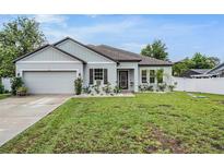 Charming one-story home with a well-manicured lawn, neutral paint, and a two-car garage at 344 Dartmouth Ave, Spring Hill, FL 34606
