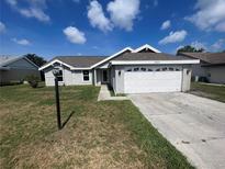 Single-story home featuring a two-car garage, neutral paint, and well-maintained landscaping under a bright, partly cloudy sky at 3541 65Th Avenue E Cir, Sarasota, FL 34243