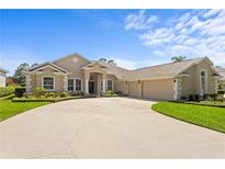 Beautiful single-story home with a three-car garage, manicured lawn, and circular driveway at 3707 Smoke Hickory Ln, Valrico, FL 33596