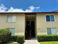 Inviting exterior featuring a quaint walkway and well-maintained landscaping leading to a two-story condo at 4215 E Bay Dr # 1707C, Clearwater, FL 33764