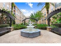 Beautiful water fountain within a community courtyard with seating, landscaping, and architecture with blue sky above at 4221 W Spruce St # 1429, Tampa, FL 33607