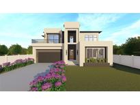 Modern two-story home boasts a clean design, balcony, and a two-car garage, complemented by a well-manicured lawn at 4316 Wallace Cir, Tampa, FL 33611