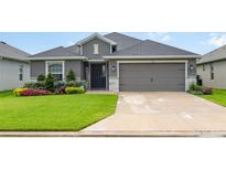 Charming single-story home featuring a well-manicured lawn and a two-car garage at 6226 165Th E Dr, Parrish, FL 34219