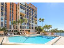 Resort-style pool and deck with lounge seating and palm trees at the base of the building at 7400 Sun Island S Dr # 412, South Pasadena, FL 33707