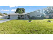 Charming single-story home featuring a metal roof and lush green lawn, providing great curb appeal at 11226 Murraysville Dr, Spring Hill, FL 34609