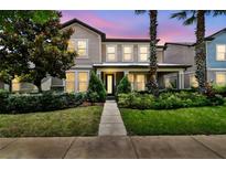 Beautiful two-story home featuring well-manicured landscaping, neutral colors, and a charming front porch at 14110 Barrington Stowers Dr, Lithia, FL 33547