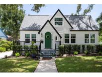 Charming home with a green door, complemented by lush landscaping and a well-manicured lawn at 1915 10Th N St, St Petersburg, FL 33704