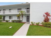 Inviting condo exterior with well-maintained lawn and path leading to the main entrance and lush landscaping at 210 Martha Ln # 210, Oldsmar, FL 34677