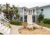 Charming coastal-style building featuring a landscaped entrance with stone accents and well-maintained exterior with stairs at 241 Skiff Pt # 1, Clearwater Beach, FL 33767