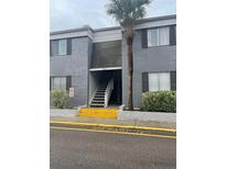 Two-story condominium building in gray with dark shutters and a palm tree at 3802 Cortez Cir # D, Tampa, FL 33614