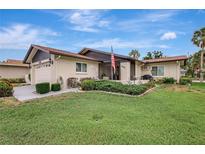 Inviting single-story home featuring a well-manicured lawn, mature landscaping, and charming front porch at 4512 Superior Ln, Clearwater, FL 33762