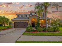 Charming two-story home featuring a well-manicured lawn, a two car garage, and a cozy front porch at 5624 Fisher Glen Loop, Wesley Chapel, FL 33545