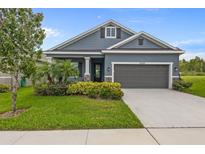 Charming single-story home with blue siding, a well-manicured lawn, and a two-car garage at 5742 Stockport St, Riverview, FL 33578