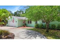 Charming home showcasing a lush front yard, with a long drive-way and an attached one-car garage at 6011 Tangerine S Ave, Gulfport, FL 33707
