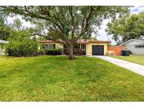 Charming single-story home with lush green lawn and mature trees at 614 12Th Nw St, Largo, FL 33770