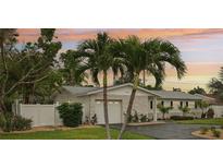 Charming home with stone accents, palm trees, manicured lawn, driveway, and an attached two-car garage at 6913 Grande Vista S Way, St Petersburg, FL 33707