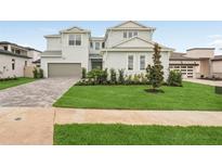 Charming two-story home with a well-manicured lawn and a brick driveway leading to a two-car garage at 8316 Golden Beach Ct, Parrish, FL 34219